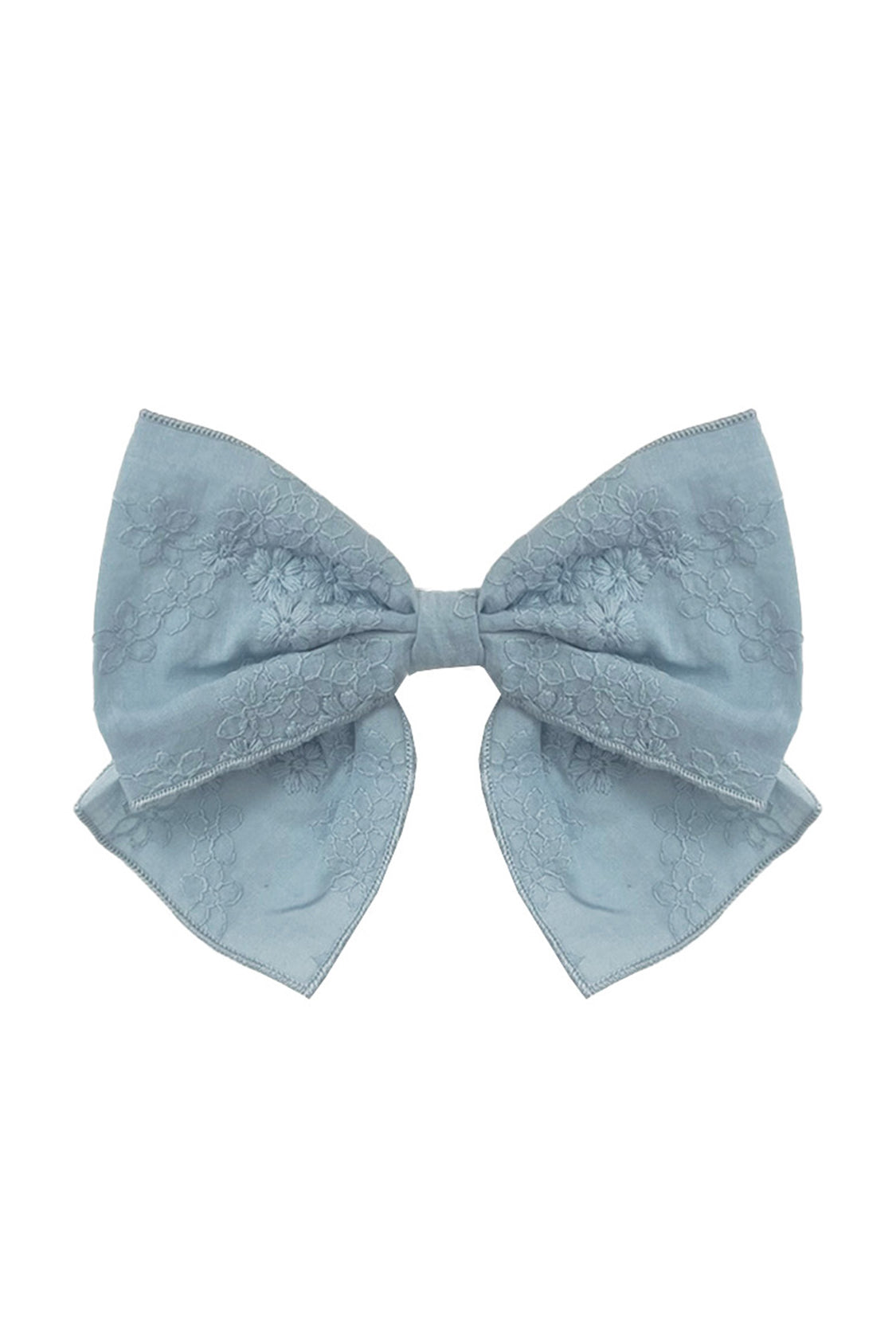 The Mabel and Honey Eva Hair Accessory is a large, light blue bow with a subtle floral pattern and gently curved ribbon tails, shown on a white background.
