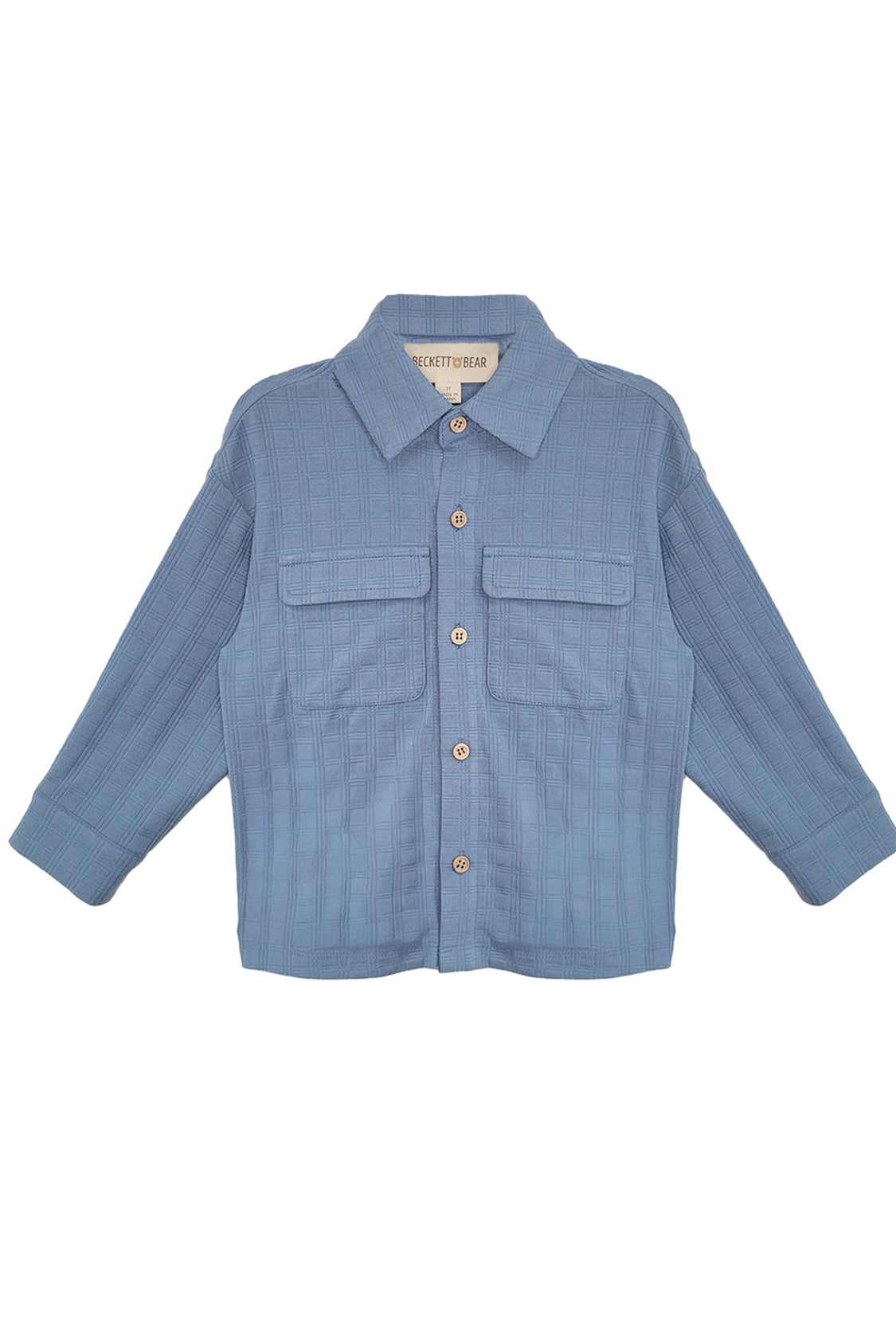 The Lucas Jacket by Beckett and Bear is a light blue, long-sleeve jacket with a collar, button-down front, two chest flap pockets, and ribbed texture. The sleeves are slightly spread out to the sides.