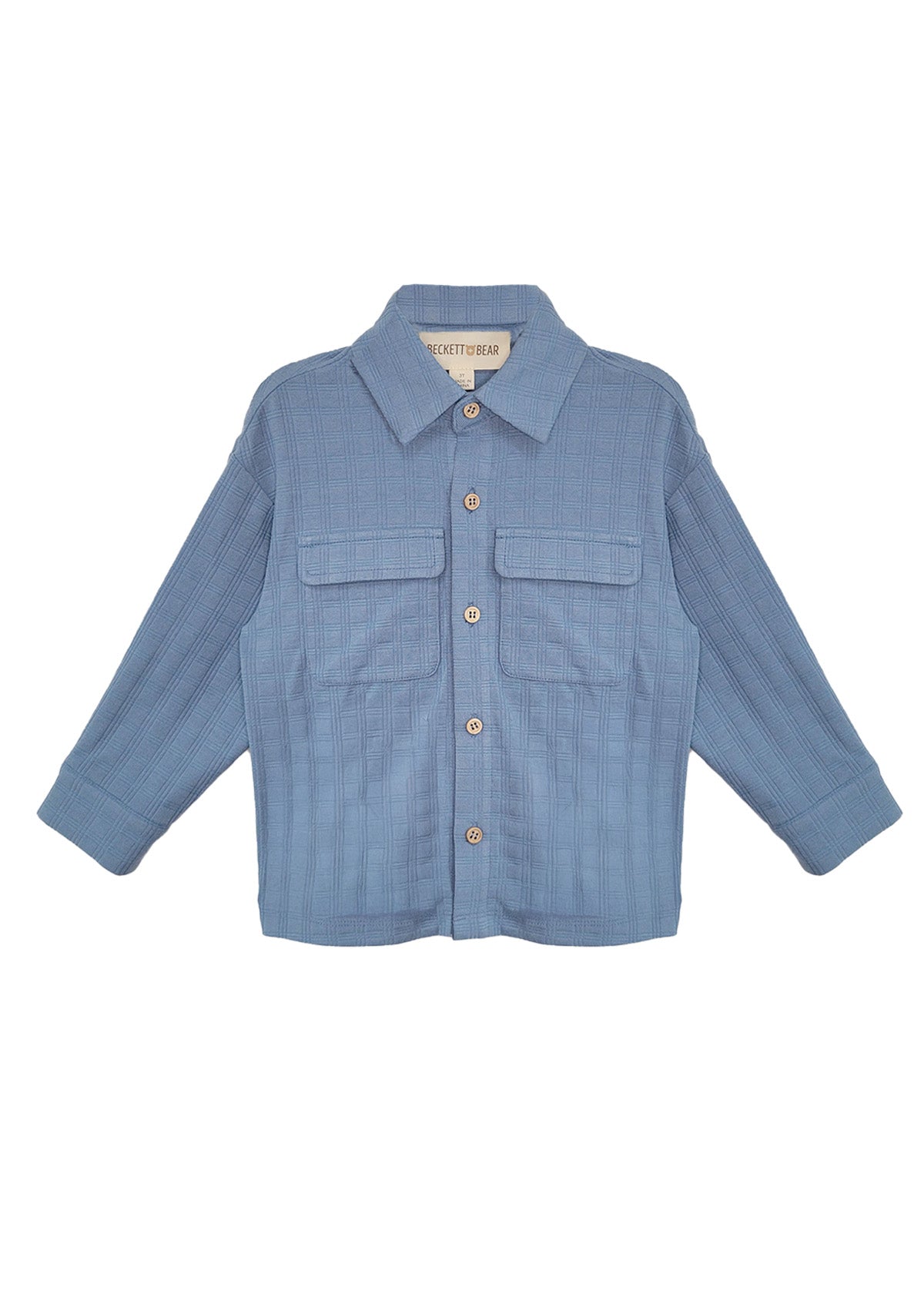 The Lucas Jacket by Beckett and Bear is a light blue, long-sleeve jacket with a collar, button-down front, two chest flap pockets, and ribbed texture. The sleeves are slightly spread out to the sides.