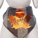 The Thankful Leaf dog bandana by Mabel and Honey features plaid cotton with a shiny copper maple leaf and “Thankful” in script—perfect for Thanksgiving. Modeled on a white mannequin, it’s stylish holiday wear for your pup.
