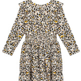 The Mabel + Honey Piper Rayon Dress is a long-sleeve girls' dress featuring a smocked waist, ruffled collar, and an all-over leopard print in black, brown, and yellow on a white background.