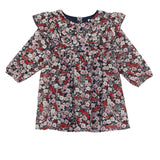 The Mabel + Honey Flora Chiffon Dress is a long-sleeve, knee-length A-line dress for children, featuring a ruffle yoke and a multicolored floral pattern in pink, red, and white on a dark background.