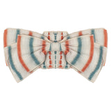 The Hermosa Headband by Mabel and Honey features orange, teal, and white stripes on textured cotton, tied in a neat bow—perfect as a charming hair accessory for your baby.