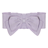 The Eloise Pink Headband by Mabel and Honey is a light purple, 100% cotton accessory featuring a large center bow and elastic ruching along the top and bottom edges.