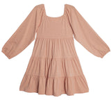 The Flower Mae Pink Dress by Mabel and Honey is a light pink, long sleeve tiered dress with a square neckline, gathered waist, elastic cuffs, bow back detail, and a loose flowy fit crafted from soft lightweight fabric.