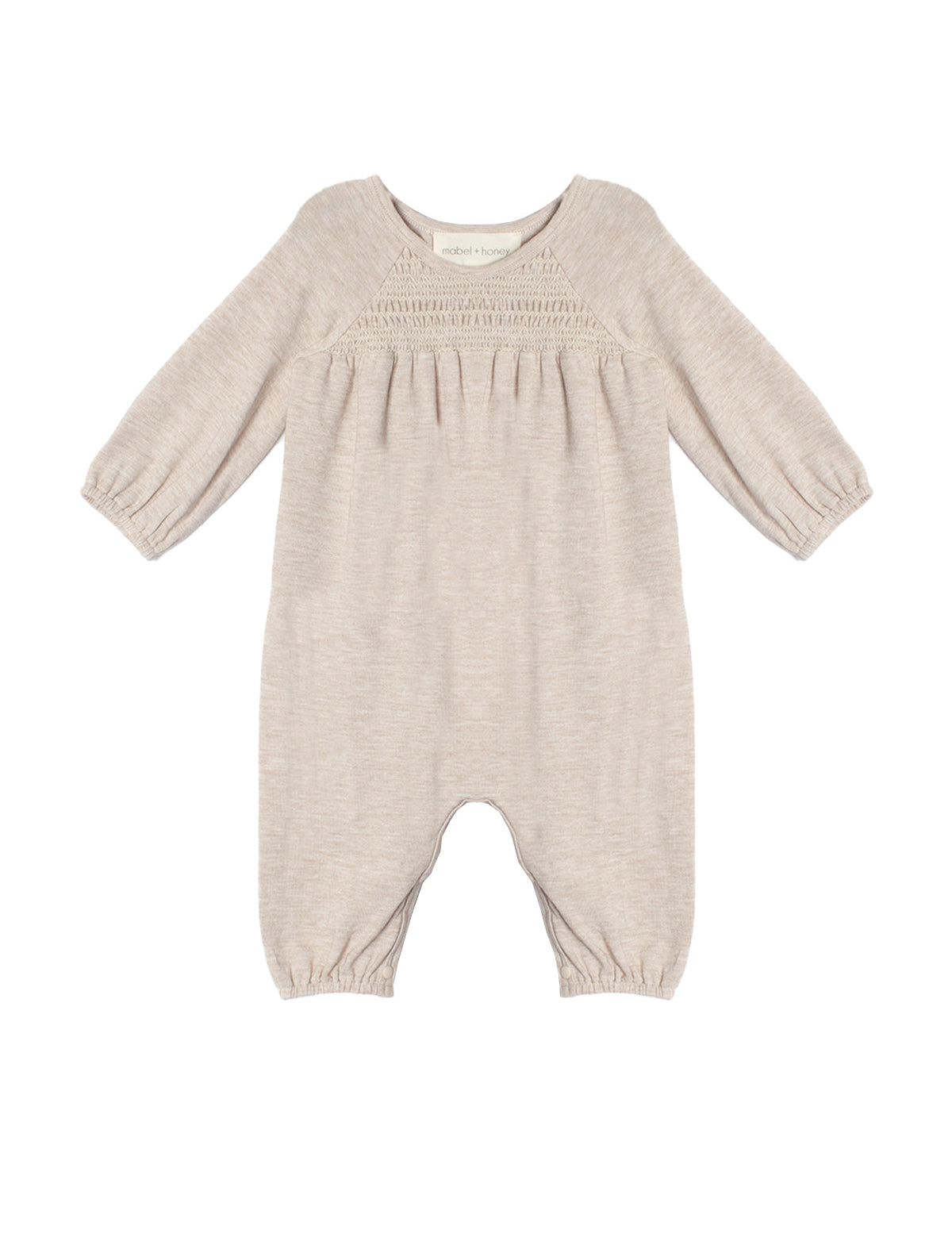 The Millie Romper by Mabel and Honey is a light beige long-sleeve one-piece with gathered elastic cuffs, a smocked pleated chest, and a classic round neckline.