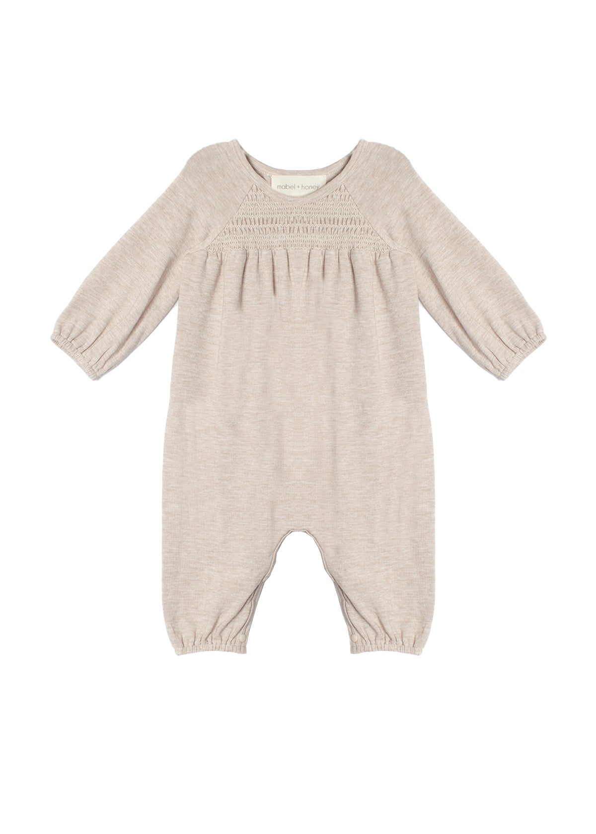 The Millie Romper by Mabel and Honey is a light beige long-sleeve one-piece with gathered elastic cuffs, a smocked pleated chest, and a classic round neckline.