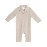 The Millie Brothers Romper by Beckett and Bear is a beige, long-sleeved romper with a collared neckline, front buttons, and inseam snaps for easy diaper changes, shown on a white background.