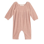 The Adore Baby Romper by Mabel + Honey is a long-sleeved, ribbed knit one-piece in light pink with gathered chest fabric and loose legs for comfort.