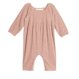 The Adore Baby Romper by Mabel + Honey is a long-sleeved, ribbed knit one-piece in light pink with gathered chest fabric and loose legs for comfort.
