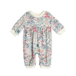 The Melody Romper by Mabel and Honey is a long-sleeve baby romper with a colorful floral pattern, cream collar and cuffs, shown on a white background.