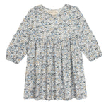 The Hazelnut Dress by Mabel and Honey is a girls long sleeve dress with a round neckline, gathered waist, and all-over blue, gray, and beige floral print on a light background—ideal for casual special occasions.