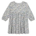 The Hazelnut Dress by Mabel and Honey is a loose-fitting, long sleeve girl’s dress with a high waist, blue-green-beige floral print, round neckline, flowy silhouette, and is ideal for casual special occasions.