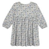The Hazelnut Dress by Mabel and Honey is a loose-fitting, long sleeve girl’s dress with a high waist, blue-green-beige floral print, round neckline, flowy silhouette, and is ideal for casual special occasions.