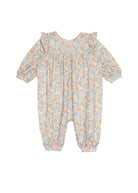 The Darling Orchard Romper by Mabel and Honey is a long-sleeve cotton baby romper with a ruffled collar and cuffs, showcasing a blue, orange, and yellow floral print on white.