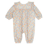 The Darling Orchard Romper by Mabel and Honey is a soft cotton, long-sleeved floral romper with ruffled shoulders and a pastel orange, blue, and yellow print on a light background—perfect for comfy, charming style for your baby.