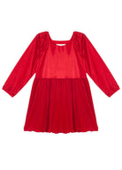 The Isobella and Chloe Merry n Bright Velvet Dress is a children’s long-sleeve red dress with a square neckline, natural waist, and pleated skirt, crafted from a shiny velvet-like fabric.