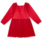 The Merry n Bright Velvet Dress by Isobella and Chloe features a bright red hue, long sleeves, natural waist, square neckline, and pleated skirt in shiny velvet—an elegant choice for holiday gatherings.