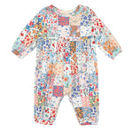 The Flower Arrangement Romper by Mabel and Honey features long sleeves, a colorful patchwork floral print in blue, red, pink, orange & green tones, with a loose fit and gathered waist for comfort and style.