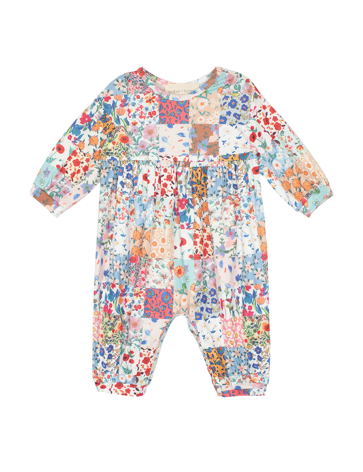 The Flower Arrangement Romper by Mabel and Honey features long sleeves, a colorful patchwork floral print in blue, red, pink, orange & green tones, with a loose fit and gathered waist for comfort and style.