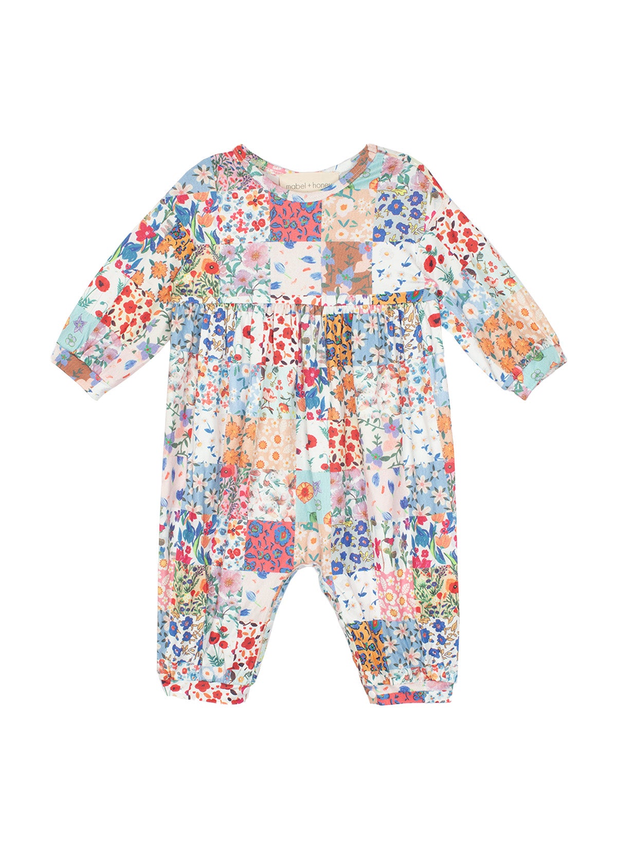 The Flower Arrangement Romper by Mabel and Honey features long sleeves, a colorful patchwork floral print in blue, red, pink, orange & green tones, with a loose fit and gathered waist for comfort and style.