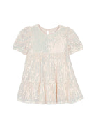 The Isobella and Chloe Taylor Sequined Toddler Dress is a light pink, short-sleeved girl's dress with shimmering iridescent sequins, a tiered skirt, and a round neckline with back button—ideal for special occasions.