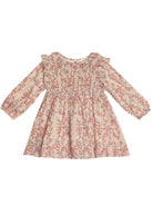 The Mabel and Honey Autumn Floral Dress Long Sleeve features a light pink base with pink and red floral patterns, smocked front bodice, and charming ruffled shoulders—perfect for your child.
