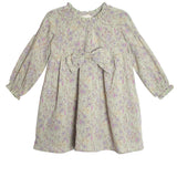 The Mabel and Honey Lavender Meadows Floral Bow Dress features long sleeves, a ruffled collar, elastic cuffs, a large front bow, and a light floral print in purple and pink—perfect for any occasion.