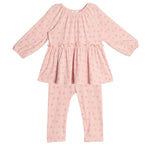 The Dainty Doodle Two Piece Set by Mabel and Honey features a pink long-sleeve peplum top with gathered flare and matching fitted pants, both with a small floral pattern. The outfit is displayed laid flat on a white background.