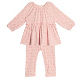 The Dainty Doodle Two Piece Set by Mabel and Honey features a pink long-sleeve peplum top with gathered flare and matching fitted pants, both with a small floral pattern. The outfit is displayed laid flat on a white background.