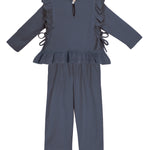 The Robyn Two Piece Set by Mabel and Honey features a dark blue cotton-blend, long-sleeve peplum top with ruffled shoulders, side ties, and back button, plus matching straight-leg pants—a charming outfit for children.