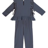 The Robyn Two Piece Set by Mabel and Honey features a dark blue cotton-blend, long-sleeve peplum top with ruffled shoulders, side ties, and back button, plus matching straight-leg pants—a charming outfit for children.