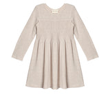 The Millie Natural Waist Dress by Mabel and Honey is a light beige, long-sleeved girl's dress with a smocked bodice and flared skirt, shown laid flat on a white background.
