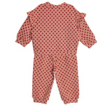 The Red Velvet Two Piece Set by Mabel and Honey features a pink toddler jumpsuit with long sleeves, ruffled shoulders, and red polka dots in soft knit fabric, shown flat on a white background.