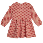 The Mabel and Honey Red Velvet Dress is a pink long sleeve dress with a flared skirt, red polka dots, ruffled shoulders, and cuff buttons for a cute, stylish look.
