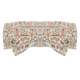 The Sunset Fields Hair Accessory by Mabel and Honey is a fabric headband with a large bow, showcasing a delicate botanical print in pink, orange, green, and blue on white.