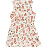 The Mavery Floral Romper by Mabel and Honey is a sleeveless, collared kids’ romper in a pink and red floral print with an elastic waistband and front buttons—perfect for sunny days.