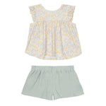 The Mila Two Piece Set by Mabel and Honey features a pastel-printed ruffle short-sleeve top in yellow and gray with solid sage green shorts, shown on a white background.