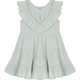 The Mila Green Emerald Dress by Mabel and Honey is a light sage green girl's dress with a sleeveless design, ruffled collar, tiered flared skirt, round neckline, and an easy back button closure.