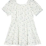 The Bluebells Drop Shoulder Dress by Mabel and Honey is a white, short-sleeved girls’ dress with a gathered bodice, flared skirt, blue floral pattern, and delicate lace trim for added charm.