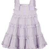The Super Bloom Tiered Dress by Mabel and Honey is a sleeveless, knee-length lavender gingham dress with white checks, ruffled tiers, and wide shoulder straps tied in bows.