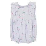 The Mabel and Honey Tiny Tulip Baby Romper features soft, lightweight lavender gauze, ruffled shoulder straps, and a charming pattern of pink tulips with green stems.