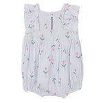 The Tiny Tulip Baby Romper by Mabel and Honey features soft lavender gauze, ruffled sleeves, a back keyhole button, and a print of green stems with pink tulips.