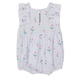 The Tiny Tulip Baby Romper by Mabel and Honey features soft lavender gauze, ruffled sleeves, a back keyhole button, and a print of green stems with pink tulips.