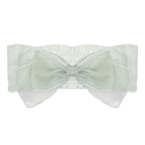 The Isobella and Chloe Jade Hair Accessory features a large pale green organza bow with layered sheer loops on a stretchy white band, creating an elegant and delicate look for girls.