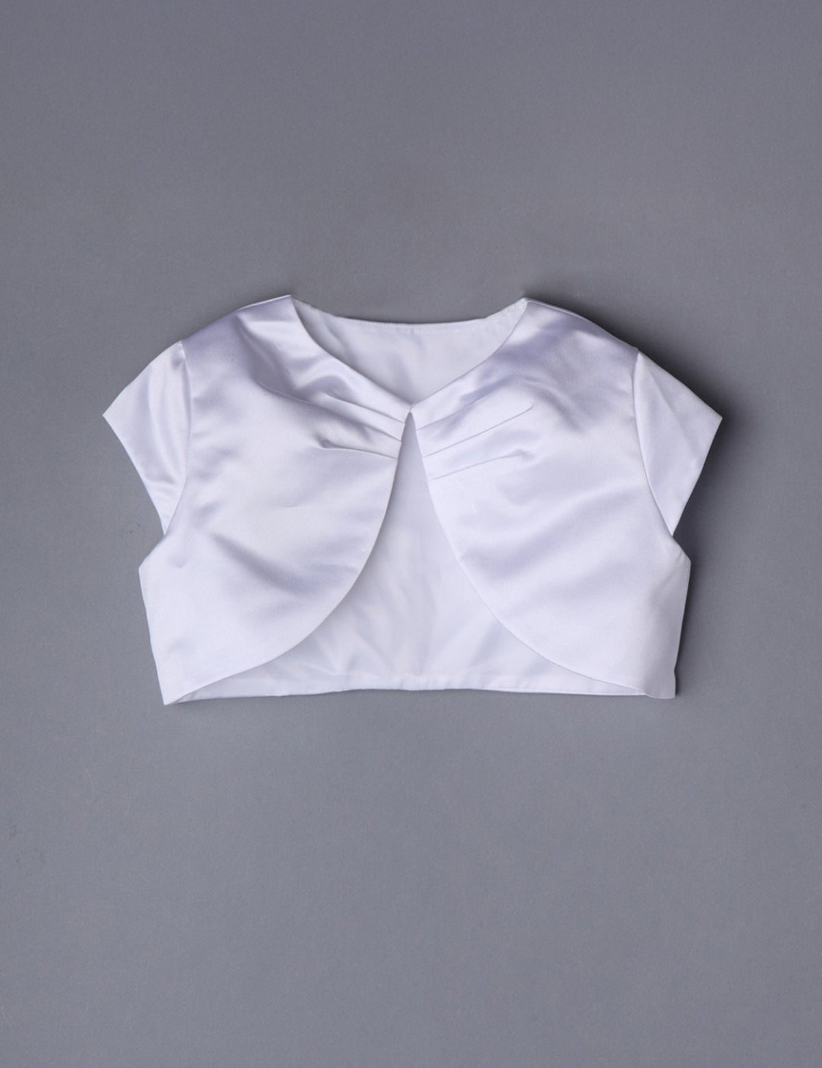 The Mabel and Honey Communion Satin Bolero features white satin, short sleeves, a rounded front opening, and gentle neckline gathering—ideal for communions or special occasions—shown on a plain gray background.