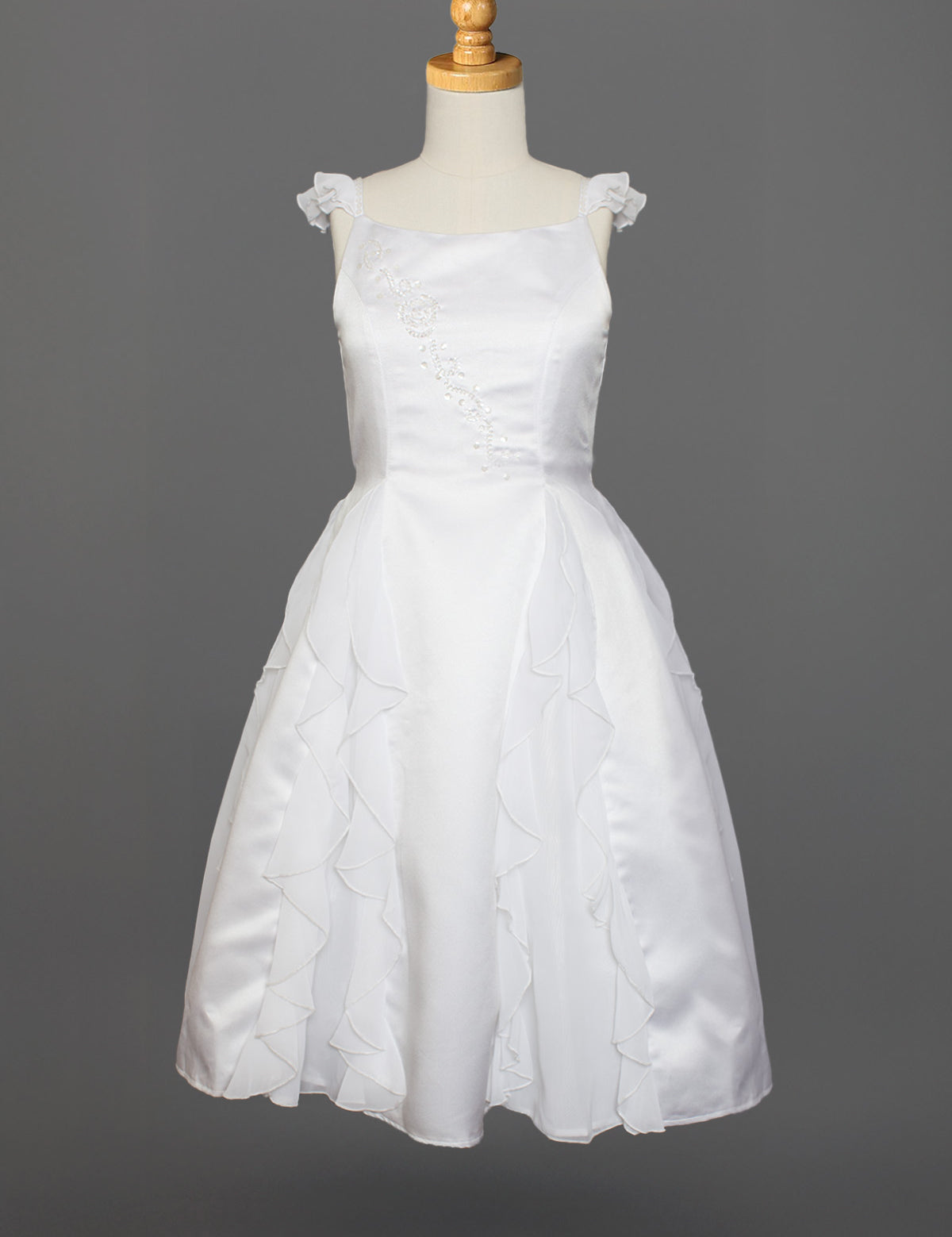The Mabel and Honey Chiffon Ruffle and Satin Flower Girl Dress features hand-beaded embellishments, ruffle cap sleeves, and a layered skirt, shown on a mannequin against a gray background.