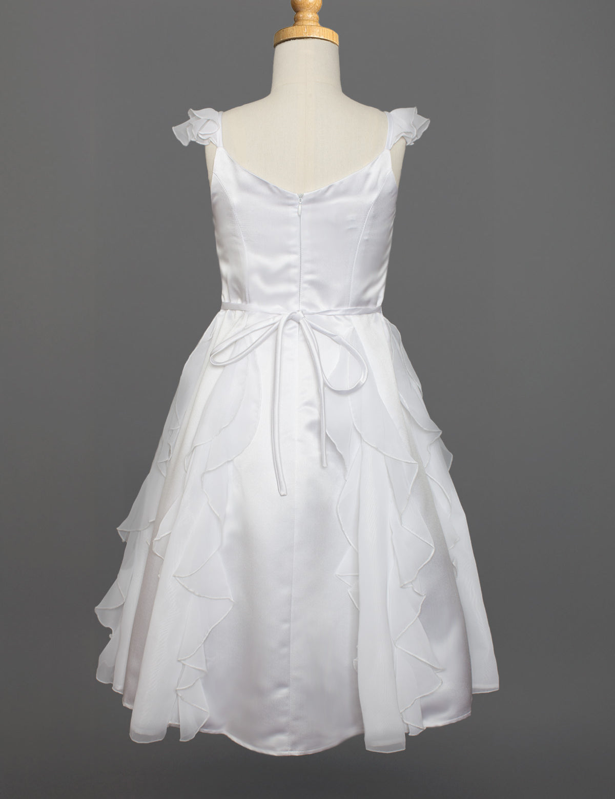 The Mabel and Honey Chiffon Ruffle and Satin Flower Girl Dress, shown on a mannequin with ruffled skirt layers, hand-beaded embellishment, and tied waist belt, is displayed against a plain gray background.