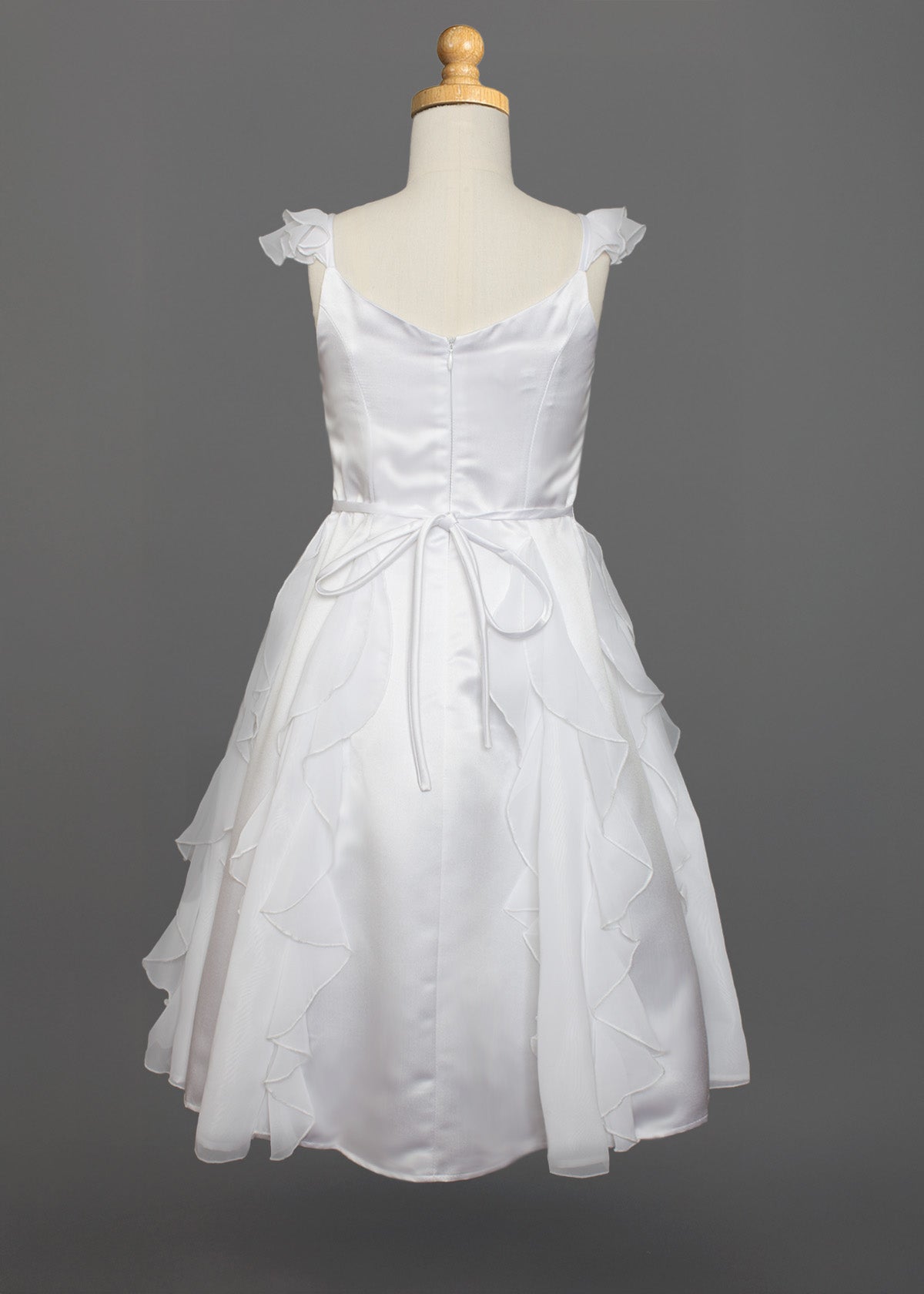 The Mabel and Honey Chiffon Ruffle and Satin Flower Girl Dress, shown on a mannequin with ruffled skirt layers, hand-beaded embellishment, and tied waist belt, is displayed against a plain gray background.
