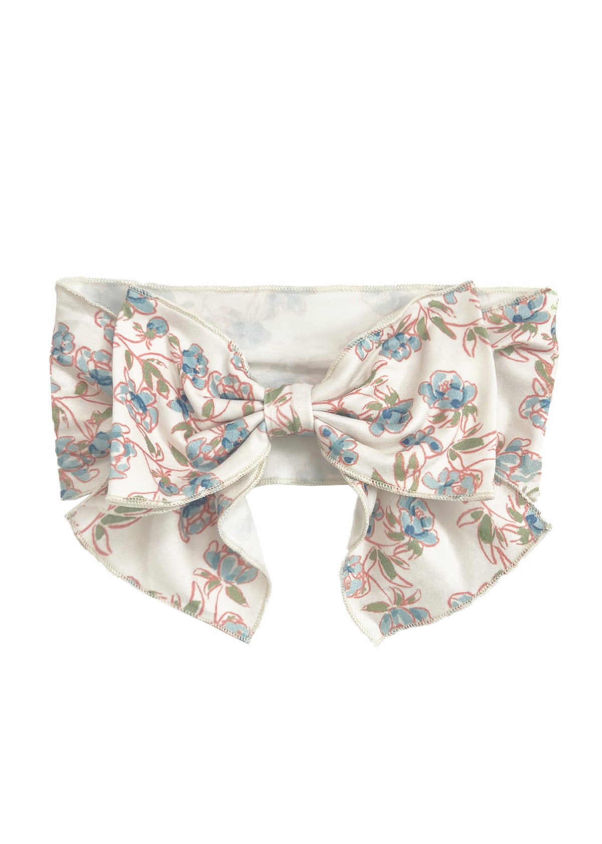 The Sadie Hair Accessory by Mabel and Honey is a wide white fabric headband with an oversized bow, decorated with a delicate blue and pink floral pattern and green stems.